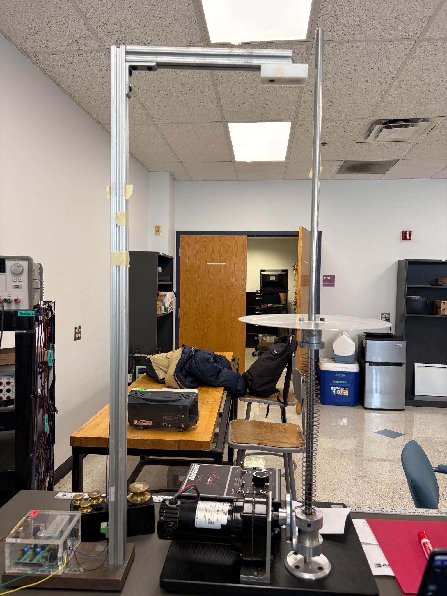 The test rig with spring, oscillating collar, drive motor, and the ultrasonic sensor mounted overhead